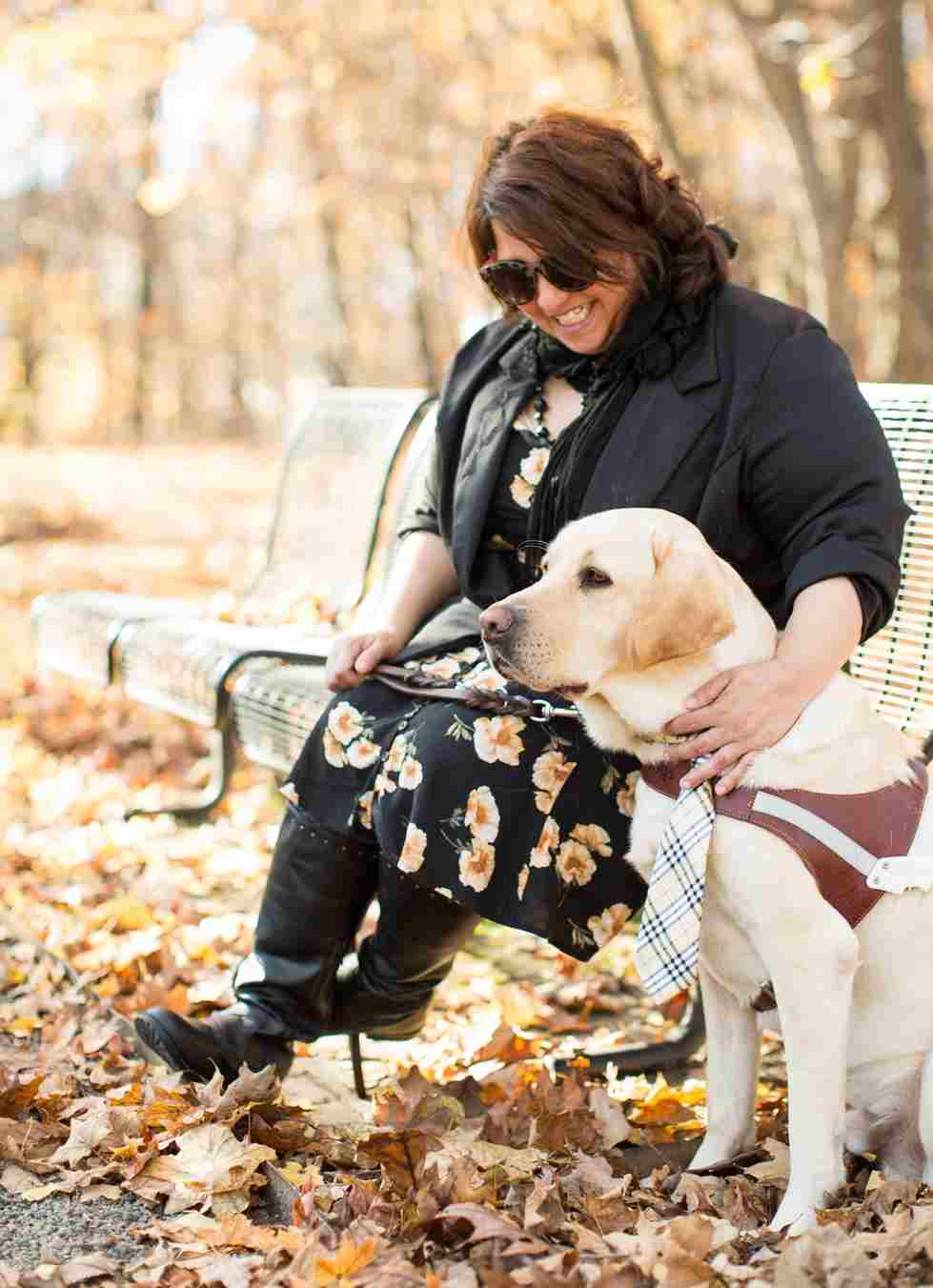 woman and guide dog on bench